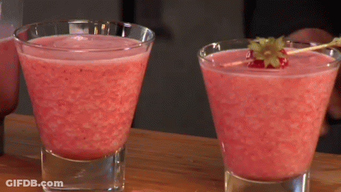 Two Glasses Of Pink Liquid With A Strawberry On A Stick GIF