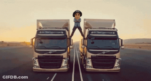 Two Globetrotter Trucks Are On The Road With A Man Standing On Top Of One GIF