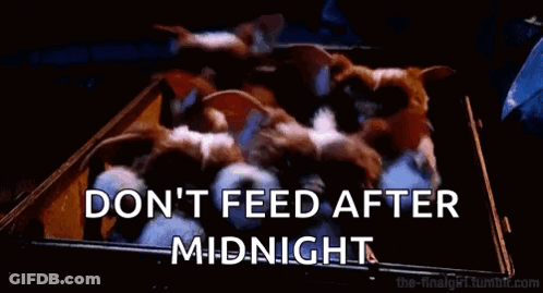 Two Gremlins Sitting In Theater Watching Movie One Holding Chips GIF
