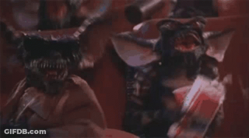 Two Gremlins Standing On Red Background GIF