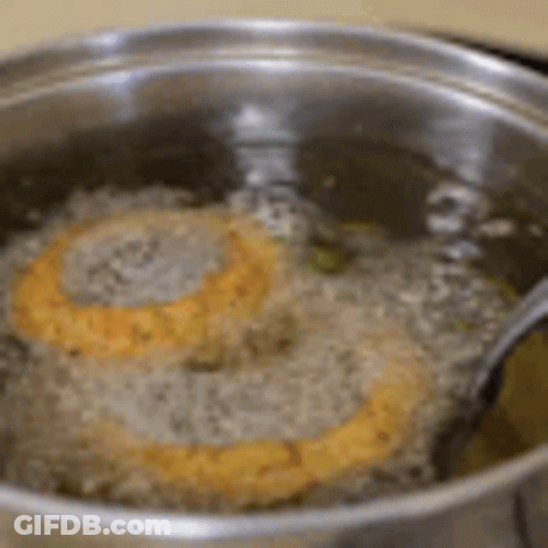 Two Hamburger Patties Cooking In Oil With Fork GIF