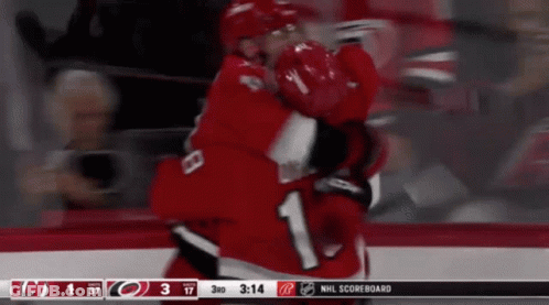 Two Hockey Players Are Hugging Each Other In Front Of A Scoreboard That Says Nhl Scoreboard On It GIF