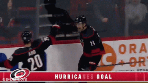 Two Hockey Players Celebrate A Hurricanes Goal In Front Of A Gatorade Ad GIF