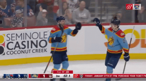 Two Hockey Players Celebrating Goal In Front Of Seminole Casino Ad GIF