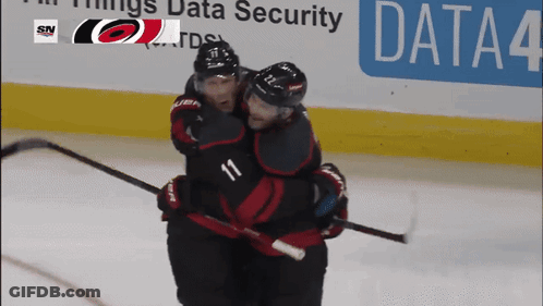 Two Hockey Players Hugging In Front Of Data Security Banner GIF