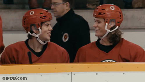 Two Hockey Players In Red Jerseys Sitting GIF