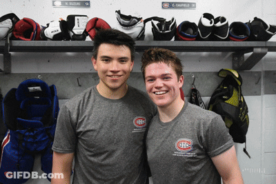 Two Hockey Players Posing In Locker Room With Gloves GIF