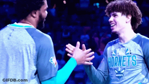 Two Hornets Players High Five Each Other On A Court GIF