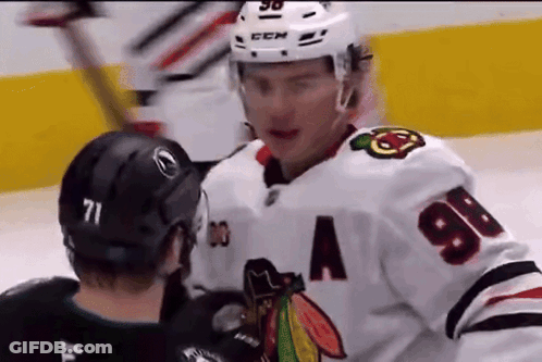 Two Ice Hockey Players Are Talking To Each Other On The Ice GIF