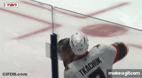 Two Ice Hockey Players Hugging During Game GIF