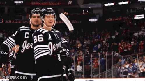 Two Ice Hockey Players In Black And White Jerseys With C86 A GIF