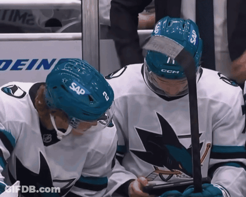 Two Ice Hockey Players Wearing Sap Helmets Looking At Something GIF