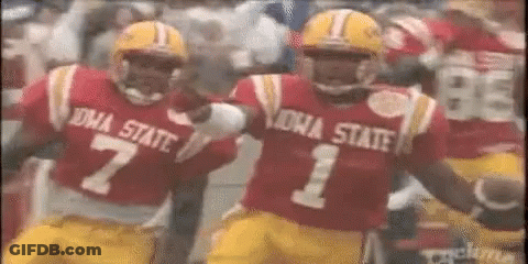 Two Iowa State Football Players Are Running On The Field . GIF
