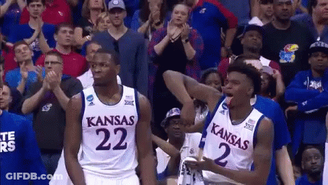 Two Kansas Basketball Players Are Standing In Front Of The Crowd GIF
