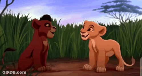 Two Lion Cubs From The Lion King Are Looking At Each Other In A Field . GIF