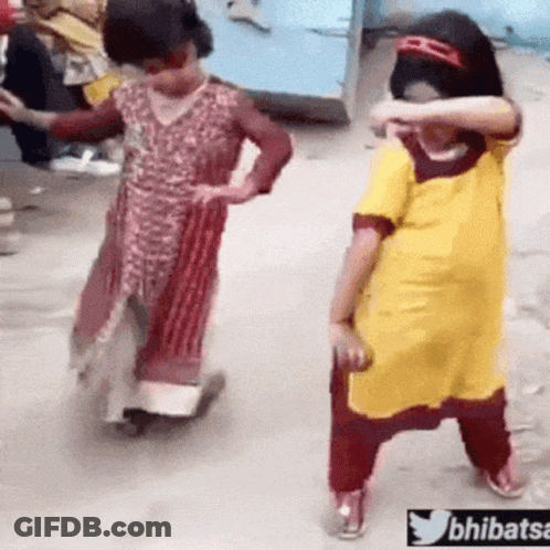 Two Little Girls Are Dancing On A Street And One Of Them Is Wearing A Yellow Shirt . GIF