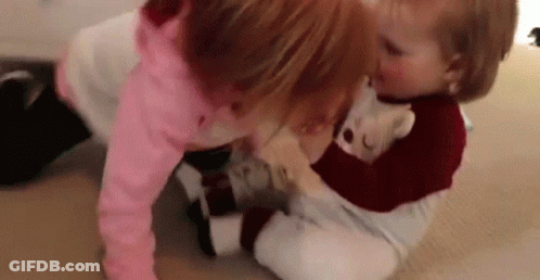 Two Little Girls Are Playing On The Floor With A Teddy Bear . GIF