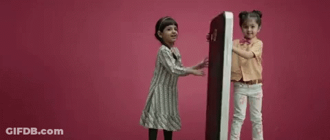 Two Little Girls Holding Large Object GIF