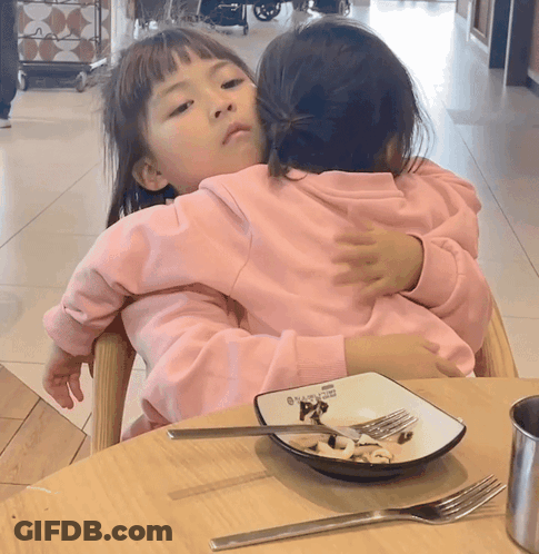 Two Little Girls Hugging With Plate Of Food GIF