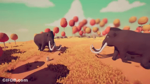 Two Mammoths Are Walking Through A Field Of Grass GIF