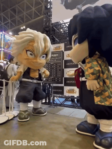 Two Mascots Are Standing Next To Each Other In Front Of Bleach Posters GIF