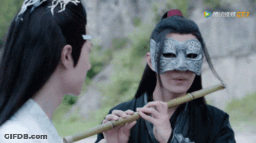 Two Masked Men, One Playing Flute GIF