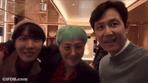 Two Men And A Woman Are Posing For A Photo Together GIF