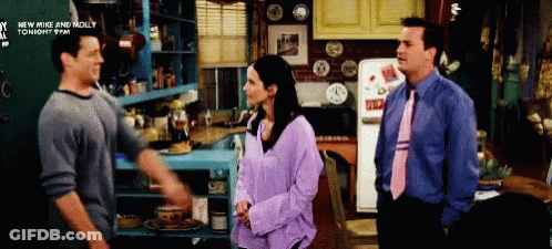 Two Men And A Woman Are Standing In A Kitchen With A Sign That Says New Mike And Molly GIF