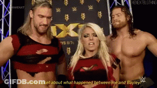 Two Men And Woman In Front Of NXT Sign GIF