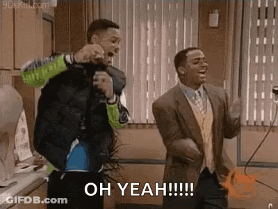 Two Men Are Dancing In A Kitchen And One Of Them Is Holding A Microphone . GIF