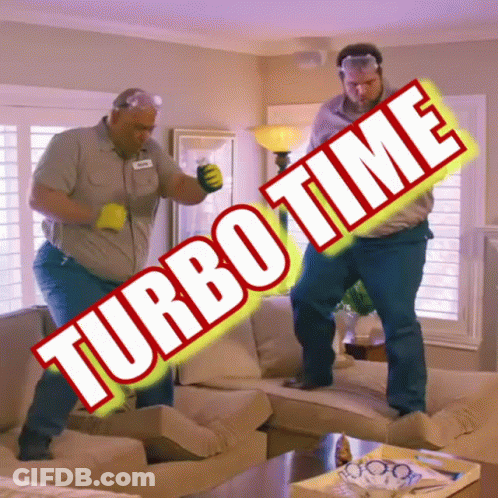 Two Men Are Dancing In A Living Room With Turbo Time Written On The Sign GIF