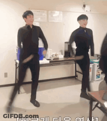 Two Men Are Dancing In A Room With Korean Writing On The Wall GIF