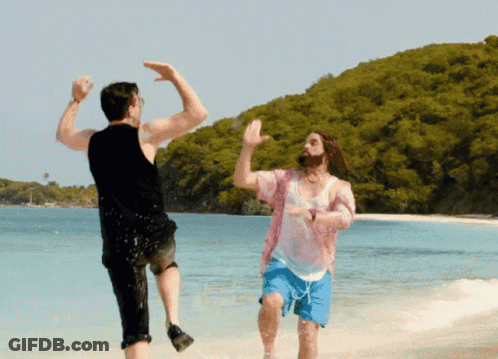 Two Men Are Dancing On A Beach And One Of Them Is Wearing A Pink Shirt And Blue Shorts GIF
