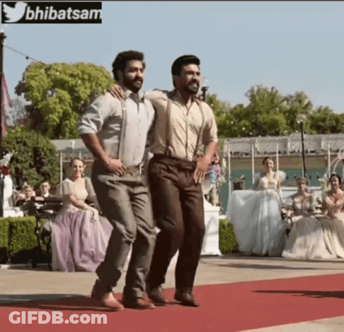 Two Men Are Dancing On A Red Carpet With A Twitter Logo In The Background GIF