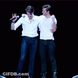 Two Men Are Dancing On A Stage Holding Hands GIF