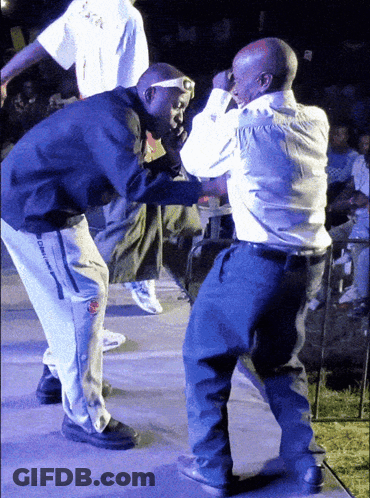 Two Men Are Dancing On A Stage With One Wearing A Shirt That Says ' Oakland ' On It GIF