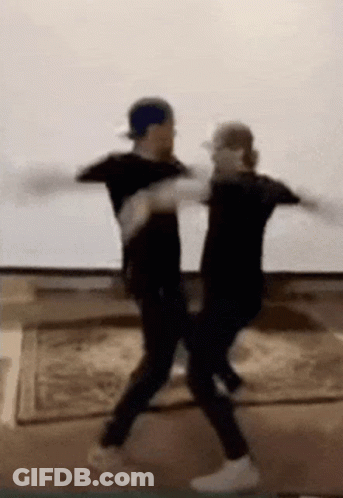 Two Men Are Dancing Together In A Living Room . GIF