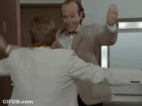 Two Men Are Dancing Together In A Room . GIF