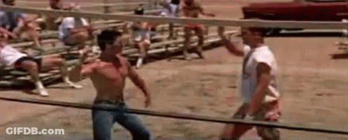Two Men Are Fighting In A Boxing Ring In Front Of A Crowd Of People . GIF