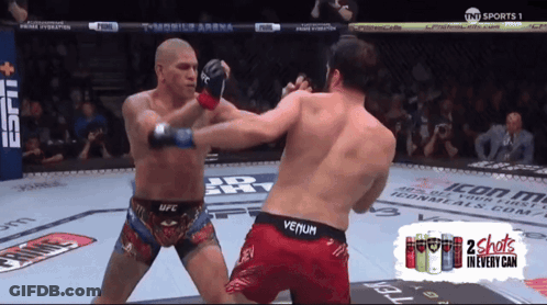 Two Men Are Fighting In A Boxing Ring With A Can Of 2 Shots In Every Can On The Bottom GIF