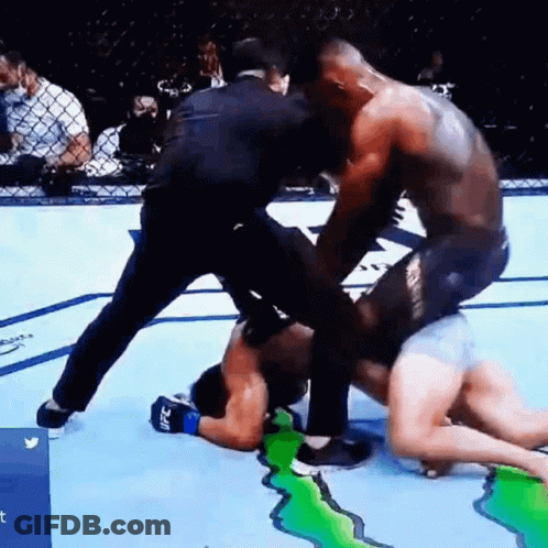 Two Men Are Fighting In A Boxing Ring With A Referee Watching . GIF