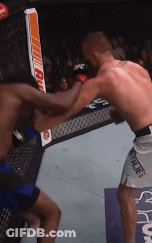 Two Men Are Fighting In A Cage And One Of Them Is Wearing Shorts With The Word Hue On Them GIF