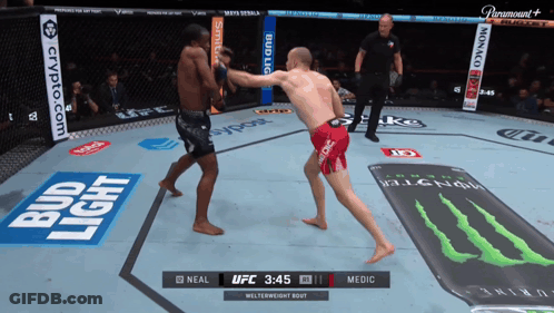 Two Men Are Fighting In A Ring With Bud Light Advertisements GIF