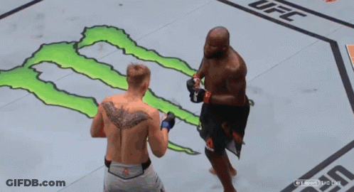 Two Men Are Fighting In A Ufc Ring With A Monster On The Floor GIF