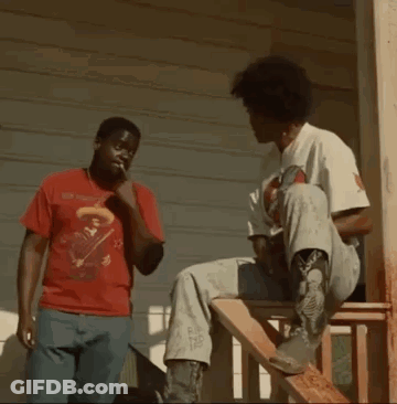 Two Men Are Fighting On A Porch While One Of Them Is Sitting On A Wooden Staircase . GIF