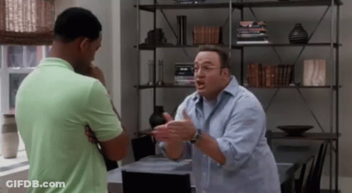 Two Men Are Having A Conversation In A Living Room . GIF