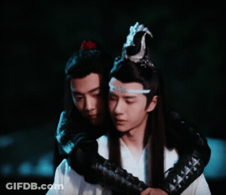 Two Men Are Hugging Each Other And One Has A Crown On His Head GIF