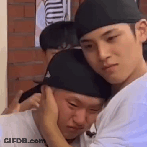 Two Men Are Hugging Each Other And One Of Them Is Putting His Hand On The Other 'S Ear . GIF