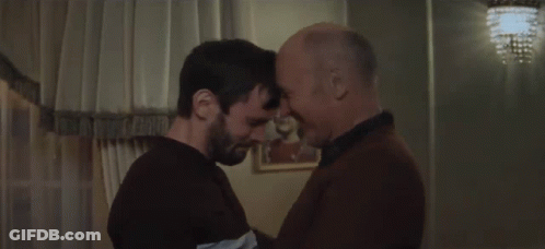 Two Men Are Hugging Each Other In A Room And One Is Holding The Other 'S Head . GIF