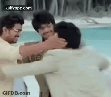 Two Men Are Hugging Each Other In Front Of A Pool . GIF